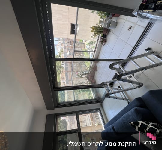תריסים סגורים על חלון זכוכית גדול בסלון